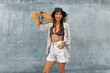 © puhhha - Skater Girl At Skatepark. Portrait Of Female Teenager In Casual Outfit With Skateboard. Hipster Posing Against Concrete Wall Outdoor. Urban Subculture Style And Summer Sport As Lifestyle.