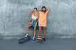 © puhhha - Couple With Skateboards Portrait. Guy And Girl In Casual Outfit Against Concrete Wall At Skatepark. Urban Subculture And Skateboarding As Lifestyle Of Active People In City.