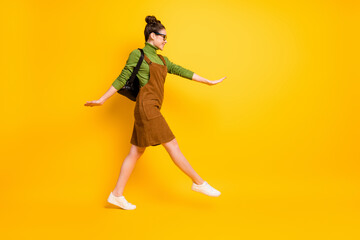 Poster - Full length body size profile side view of her she attractive cheerful smart clever girl nerd jumping going back to school attending courses isolated bright vivid shine vibrant yellow color background