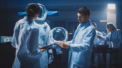 diverse team of aerospace scientists and engineers wearing white coats have discussion, use computer