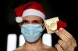 © Oleg - Condom and red knitted heart in male hand close up, man in medical face mask and Santa Claus hat giving present. Safety sex at Christmas during coronavirus pandemic