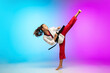 © master1305 - Powerful. Karate, taekwondo girl with black belt isolated on gradient background in neon light. Little caucasian model, sport kid training in motion and action. Sport, movement, childhood concept.