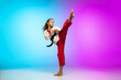 © master1305 - Hitting. Karate, taekwondo girl with black belt isolated on gradient background in neon light. Little caucasian model, sport kid training in motion and action. Sport, movement, childhood concept.