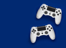 Two White Game Controllers On Blue Background