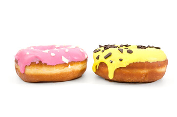 two sweet donuts in pink and yellow glaze and with chocolate sprinkles isolated on a white background. Side view.