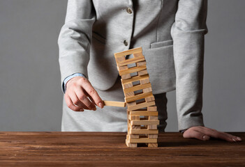 Wall Mural - Businesswoman removing wooden block from tower