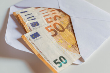 Pile of 50 Euros notes inside white envelope.