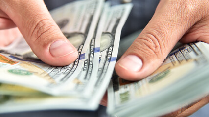 Close up of businessman counts money in hands.