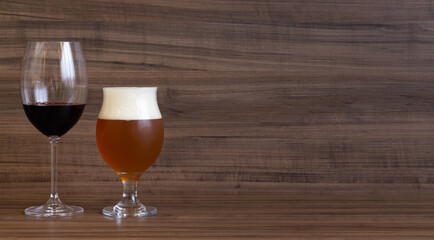 Glass of wine and glass of beer on wooden bar counter