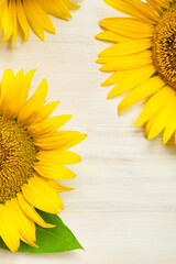 Wall Mural - Frame made of Yellow sunflowers on white wooden background top view copy space. Beautiful fresh sunflowers, yellow flowers bouquet. Harvest time, farming Agriculture autumn or summer floral background