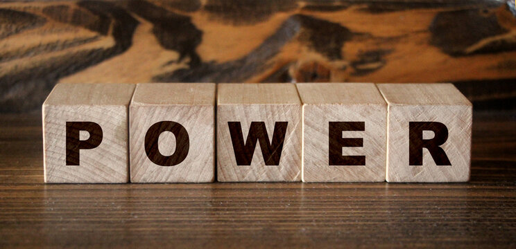 Concept word forming on wooden cube on white background - power