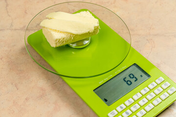 piece of the butter on a light green kitchen digital scale