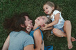 © Summer Murdock - Overhead view of mother with her daughters relaxing on grass in backyard