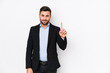 © Asier - Young caucasian business man against a white background isolated showing number one with finger.