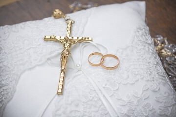 gold rings and cross on the wedding cushion