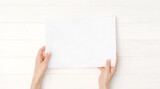 Fototapeta Mapy - Hands holding blank white paper a4 size for design