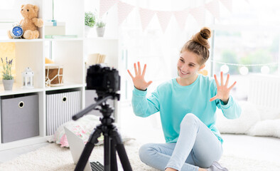 Wall Mural - Blogger girl shooting vlog on camera in light room