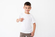 © Ievgen Skrypko - Happy little boy pointing at blank white t-shirt with copy space