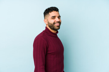 Wall Mural - Young mixed race arabic man isolated looks aside smiling, cheerful and pleasant.