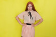 © yevgeniya131988 - Single gorgeous young red haired woman in pink blouse and skirt posing over yellow background