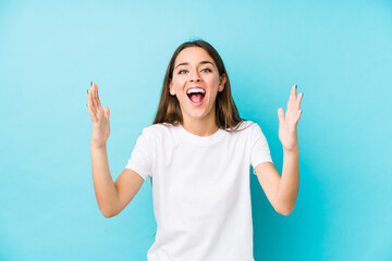 Wall Mural - Young caucasian woman  isolated receiving a pleasant surprise, excited and raising hands.