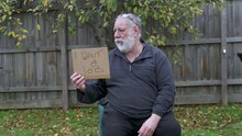 A Homeless Man In A Park Holding A I Want A Job Card