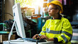 © khwanchai - Woman with yellow helmet work on computer inside the heavy industry factory, female industrial engineer works on personal computer typing and check equipment