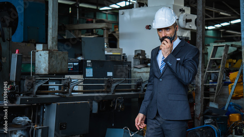 Fotomural industrial manager in suit and wearing white protect helmet, check and control w