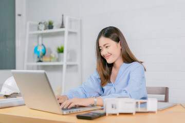 Wall Mural - Asian architect man and woman working with laptop and blueprints,engineer inspection in workplace for architectural plan,sketching a construction project ,selective focus,Business concept