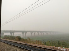 A Shot Taken From Inside Of A Train. A View Of A Bridge Covered In Fog, Delhi India.