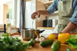 © Svitlana - Cropped shot of man, Italian cook pouring a glass of white wine into the pan with chopped vegetables while preparing a meal in the kitchen