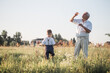 © Maria - Happy senior man Grandfather with cute little boy grandson playing in field. Happy child with Grandfather playing outdoors
