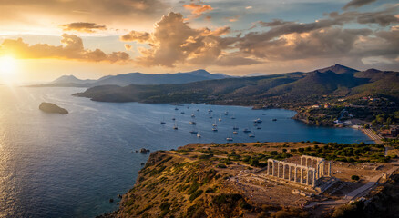 Wall Mural - Panorama des Kap Sounion bei Athen zum Sonnenuntergang mit Tempel des Poseidon und zahlreichen Segelbooten vor Anker in der Bucht, Attika, Griechenland