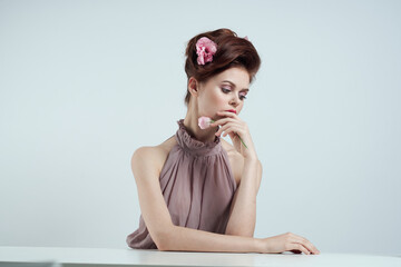 romantic woman with flowers in her hair and vase with pink flower light background table