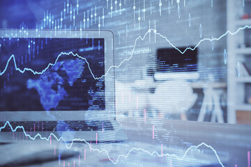 Stock market graph on background with desk and personal computer. Multi exposure. Concept of financial analysis.