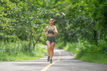 Young woman running outdoors in a green park on a lovely sunny summer day.