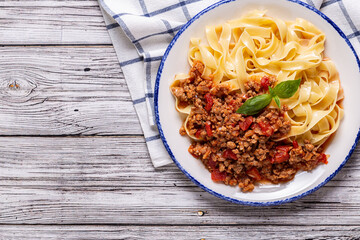 Wall Mural - Traditional italian pasta bolognese on a white plate on a wooden background