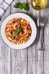 Wall Mural - Traditional italian pasta bolognese on a white plate on a wooden background