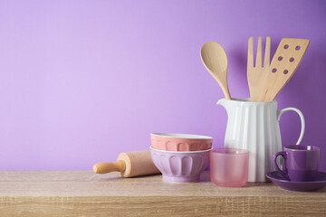 Wall Mural - Kitchen utensils and dishware on wooden shelf. Kitchen interior purple background