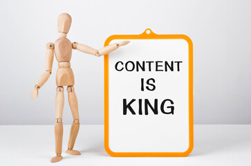 Poster - Wooden man shows with a hand to white board with text Content is King