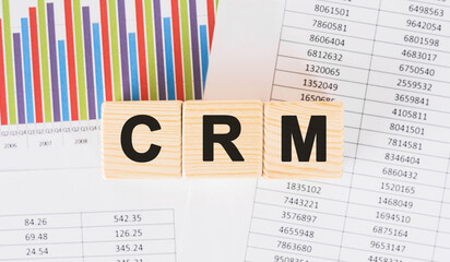 Poster - crm word written on wood block. faqs text on table, concept.