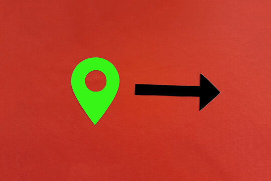 A green geolocation sign with an arrow pointing to a black path on a red background.