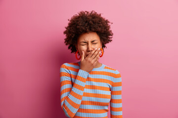 Wall Mural - Grieved displeased Afro American woman covers eyes, cries from despair, has frustrated face expression, wears casual striped jumper, has big problem, depressed over something. Emotional burnout