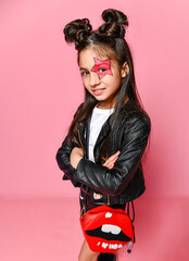 Wall Mural - Little fashionable girl hipster punk - dressed in a leather jacket and skirt, black loaches and a white T-shirt, with a funny hairstyle and painted makeup star on her face.