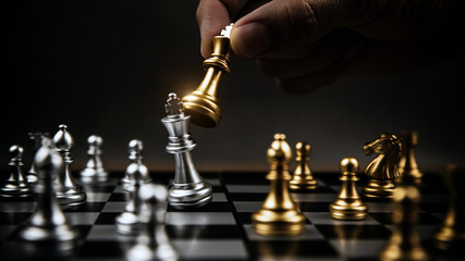 Close up hand choose gold chess to fight with silver chess team on chess board Concept of business strategic plan and professional teamwork and challenge management.