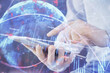 © peshkova - Double exposure of man's hands holding and using a digital device and forex graph drawing. Financial market concept.