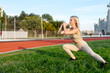 © Maria - Beautiful young blonde doing lunges exercises during training in the stadium