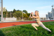 © Maria - Beautiful young blonde doing lunges exercises during training in the stadium