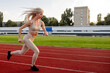 © Maria - Beautiful young blonde woman runs on a treadmill in the stadium