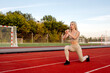 © Maria - Beautiful young blonde doing lunges exercises during training in the stadium